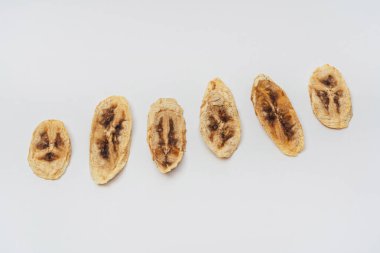 Beyaz arka planda kurutulmuş muz dilimleri. Yemek ve içecek hazırlamak için kurutucuda kurutulmuş muz. hafif arkaplanda muz cipsi