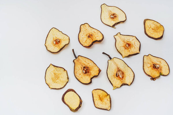 dried pear slices on a white background. banana dried in a dehydrator for preparing food and drinks. banana chips on a light background