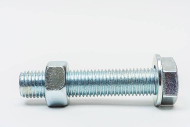 Beyaz arka planda bir grup civata ve fındık. Arka planda cıvatalar, çamaşır makineleri ve fındıklar birleştirildi. Katalog için iplikli bağlayıcıların fotoğrafı