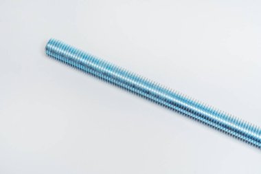 Beyaz arka planda demir başlıklı damızlık. Hafif arka planda iplik olan metal çubuk. Bağlanmak için iplikli uzun cıvata inşaatı