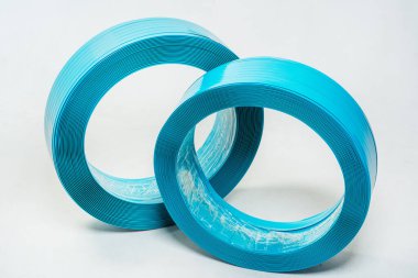 Beyaz arka planda mavi polyester bant. Arka planda hafif bir rulo halinde yüksek güçlü temoplastik bant. rulo içinde bant paketleme materyali