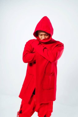 Beyaz arka planda Koreli bir adamın fotoğraf çekimi. Yarım yamalak yüzlü, şık bir pelerinli Koreli manken. Fotoğraf stüdyosunda bir mankenle birlikte gençlik kıyafetlerinin fotoğraf çekimi.