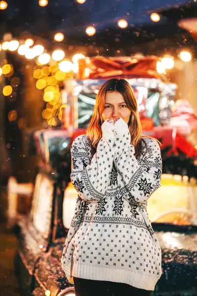 photo shoot of a girl in a warm hoodie on Christmas day. photo of a woman in a New Year\'s sweater at a Christmas car. photo shoot of a person on New Year\'s decorations in a photo studio in Kazakhstan
