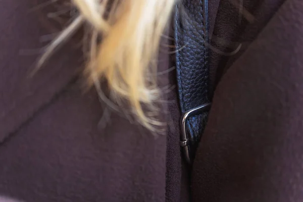 the strap of the backpack on the girl\'s shoulder. detail of a black backpack on a woman
