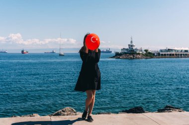 İstanbul rıhtımında elinde kırmızı bir balonla siyah elbiseli bir kız. Denizin arka planında Türk balonu olan Rus kız. Türkiye 'de bekar bir kadın