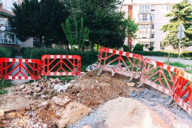 Boru döşemek için yükleyicisi olan açık bir çukur. Şehirdeki iletişimi geliştirmek için asfalt bir yol. İnşaat işleri için siperlerin hazırlanması