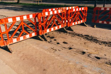 Kırmızı bir çit geçidi kapatıyor. Yol tamiri sırasında yayaları korumak için çit inşa etmek. Tamir sırasında plastik çit