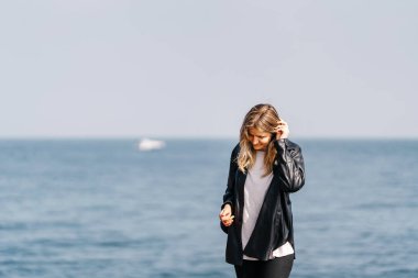 İstanbul 'da denizin arka planında deri ceketli beyaz bir kız. Türkiye 'de bir Rus kız. Siyah ceketli sarışın bir kadın.