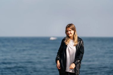 İstanbul 'da denizin arka planında deri ceketli beyaz bir kız. Türkiye 'de bir Rus kız. Siyah ceketli sarışın bir kadın.