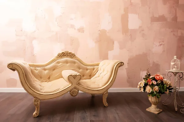 beige sofa on a peach wall background. a ready-made photo zone with a sofa in the photo studio. a piece of furniture on a plain wall