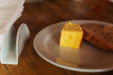 Tahta bir masada beyaz bir tabakta bir parça ekmek ve kek. Yüksek kalite fotoğraf 