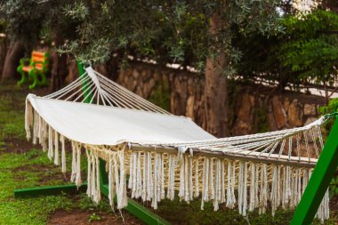 Huzurlu bir bahçede, rahat bir hamak düşünceli bir şekilde sağlam bir ağaca asılır, rahatlamak için mükemmel bir yer yaratır.