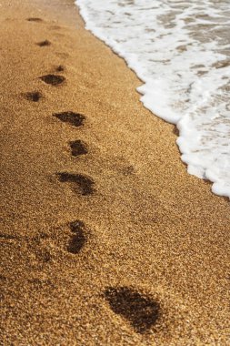 Kumlu sahilde güzel dalgalar ve ayak izleri. Yüksek kalite fotoğraf