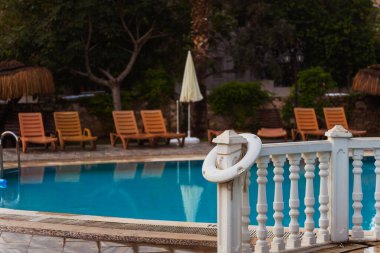 Rahat sandalyeler ve uzun, davetkar palmiye ağaçları ile çevrili ferah bir yüzme havuzu var. Rahatlatıcı bir ortam yaratıyor.