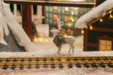 Small toy Christmas reindeer for shopping mall decoration. A miniature town with deer. High quality photo clipart