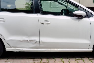 Beyaz arabanın arka kapısı göçmüş. Otoparktan kaynaklanan metal araba hasarı. Yüksek kalite fotoğraf