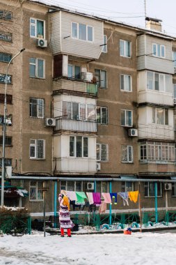 Zavallı kadın Kazakistan 'da kurutmak için çamaşır asıyor. Shymkent sokaklarında çamaşır kurutmak. Yüksek kalite fotoğraf