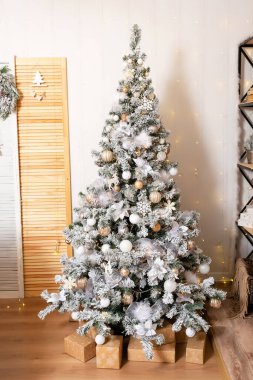 Kara raflı dallarda kar olan yeni yıl ağacı. Odada Noel ağacı olan bir süsleme. Yüksek kalite fotoğraf
