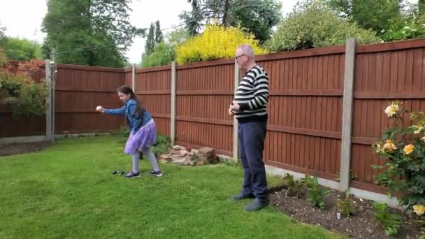 白人少年と母は庭のスプリンクラーで彼の裏庭で遊んでいます — ストック動画