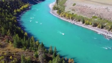 Turkuaz gayzer gölünün üzerinde şeffaf maden suyu ve göl yatağında mavi kil olan bir hava. Yeşil ormanla çevrili bir göl. Doğada güzellik