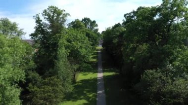 Aerial top down view from the drone on the narrow passageway leading to a small chapel. Chapel located in a big green open area of fields near Rosary Manor, Mill Hill, North West London, London, UK.