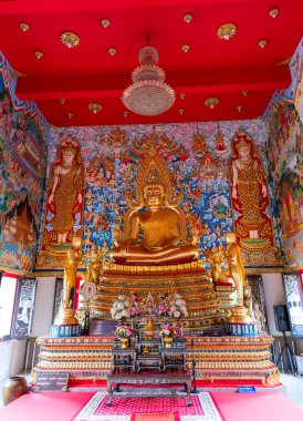 Huzurlu iç mekanda heybetli bir Buda heykeli ve rahatlatıcı bir tapınak atmosferinde renkli resimler var.