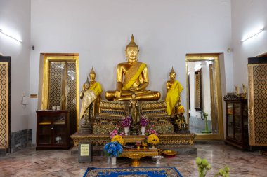 Nefes kesici bir altın Buda heykeli güzel bir şekilde davetkar ve huzurlu bir tapınak atmosferiyle çevrilidir.