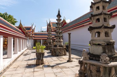 Huzurlu ve huzurlu bir tapınak avlusu güzel bir şekilde sergileniyor. Çimenli yeşilliğin yanında ayrıntılı yapılar da var.