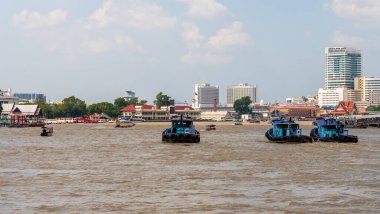 Kıvrımlı bir nehrin hareketli manzarası. Canlı bir şehir zeminine karşı sayısız tekne.