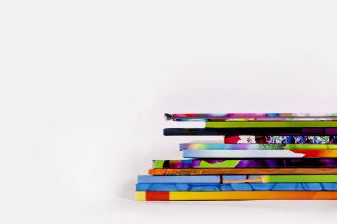 A stack of books on a white background. Books on the tables in the university library. Lots of books with colorful covers. Children's books for reading