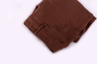 Beyaz arka planda kahverengi kot pantolon. Kahverengi yaz pantolonu. Klasik erkek kotu. Yolculuk için erkek kıyafetleri.