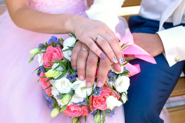 Gelinlerin düğün buketi. Evlilik yüzükleri yakın plan. Küçük bir buket kırmızı ve beyaz gül