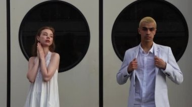 Genç kız ve erkek, pencerelerin siyah yuvarlak pencerelerinin arkasında oturuyorlar. 4K Çözünürlüğü