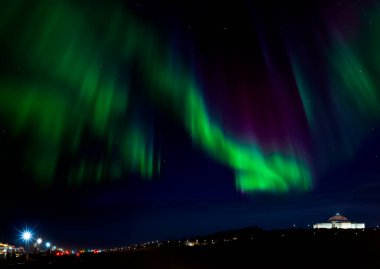 Aurora Borealis, Reykjavik, İzlanda 'daki Perlan binasının üstünde. Auroras (kuzey ve güney ışıkları), özellikle kutup bölgelerinde gökyüzünde doğal ışık gösterimidir. Bunlar iyonosferde meydana gelir.. 