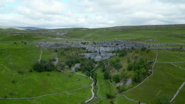 İngiltere 'nin kuzeyindeki Kuzey Yorkshire Dales' deki Malham Koyu 'nun havadan görüntüsü. Malham Koyu, 12.000 yıldan uzun bir süre önce buzul çağından eriyen suyu taşıyan bir şelalenin oluşturduğu büyük kıvrımlı bir kireçtaşı oluşumudur..