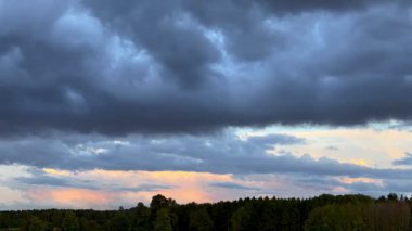 Kırsal bir arazide alacakaranlıkta gökyüzünde hareket eden bulutların zaman akışı