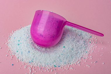 Pembe arka plan manzarasında plastik kaşıkla yıkama tozu. Yüksek kalite fotoğraf