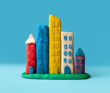 Mavi arka planda izole edilmiş plastik modelleme kil, çocuklar oyuncak, çocuklar eğlence konsepti, emlak konsepti, küçük şehir