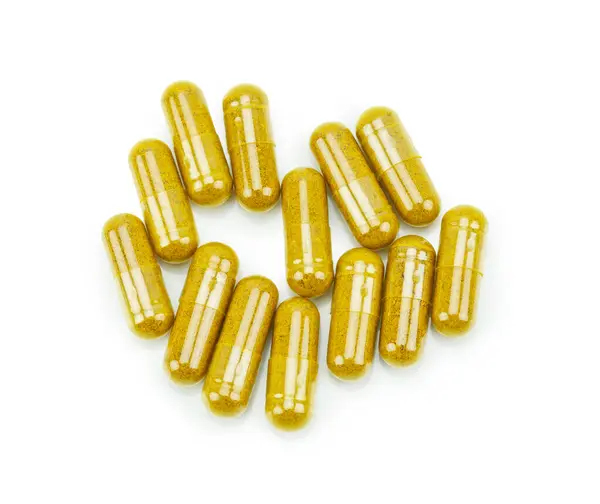 Beyaz arkaplanda zerdeçal kapsülü tozu