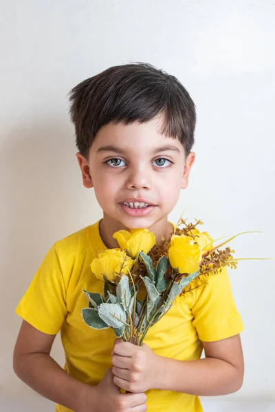 Cute and happy boy with yellow t-shirt - Holding bouquet of flowers