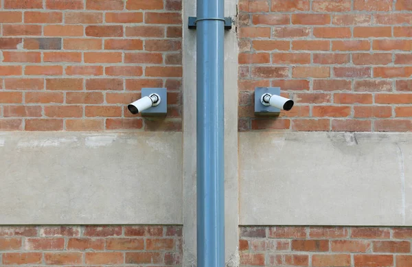 Kırmızı Tuğla Duvara Yerleştirilmiş Iki Güvenlik Kamerası — Stok fotoğraf
