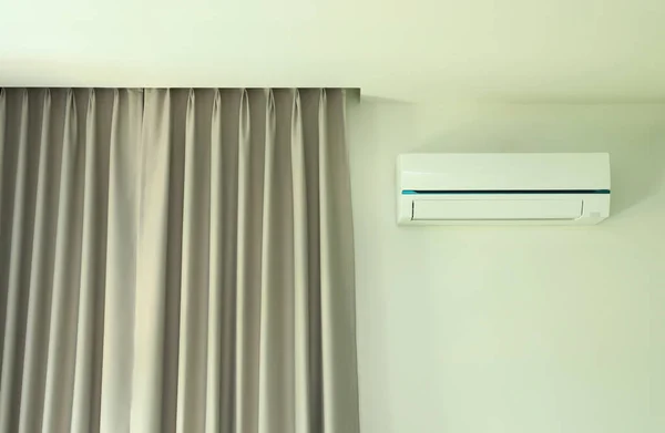 Air conditioner wall type with curtain in white wall room.