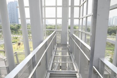 Etrafı çelikle çevrili beyaz çelik çerçeve yapısı Tayland 'ın başkenti Bangkok' taki Queen Sirikit Park 'taki Pupha Mahanatee Garden' daki Kuş Gözetleme Kulesi 'nin içindeki çelik ızgaralarla kaplı..