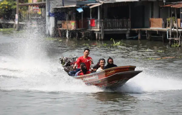 BANGKOK, THAILAND - 12 Şubat 2024 'te Bangkok Tayland' daki Phasi Charoen kanalı boyunca uzun kuyruklu tekneyle yüksek hızda seyahat eden tanımlanamayan yolcular.