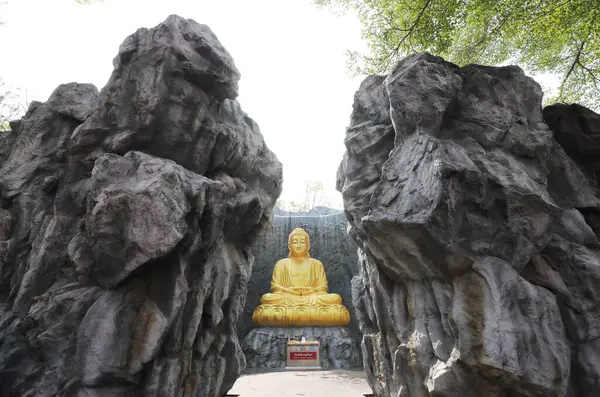 Wat Lak Si Rat Samoson, Samut Sakhon, Tayland 'daki şelale ve taş duvarlı büyük altın Buda heykeli..