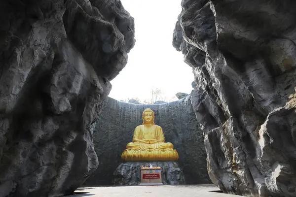 Die Große Goldene Buddha Statue Mit Wasserfall Und Steinmauer Hintergrund lizenzfreie Stockbilder