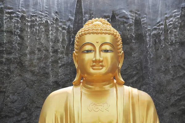 Den Stora Gyllene Buddha Statyn Med Vattenfall Och Stenmur Bakgrunden Stockbild