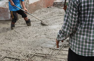 İnşaat işçileri zemin kata güçlendirilmiş levha döküyorlar..