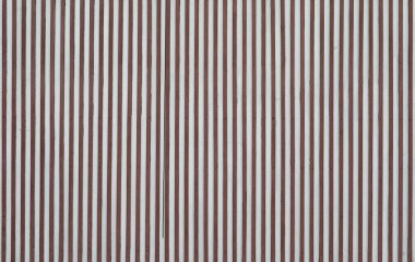 Beyaz beton duvarda ince ahşap bir katman var.