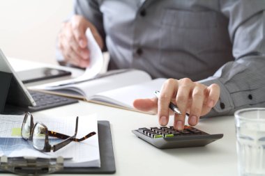  Ofis masasında hesap makinesi, belgeler ve gözlüklerle çalışan bir iş adamının yakın çekimi. Muhasebe, mali planlama, vergi hesaplama, işletme yönetimi ve kurumsal finans kavramı.